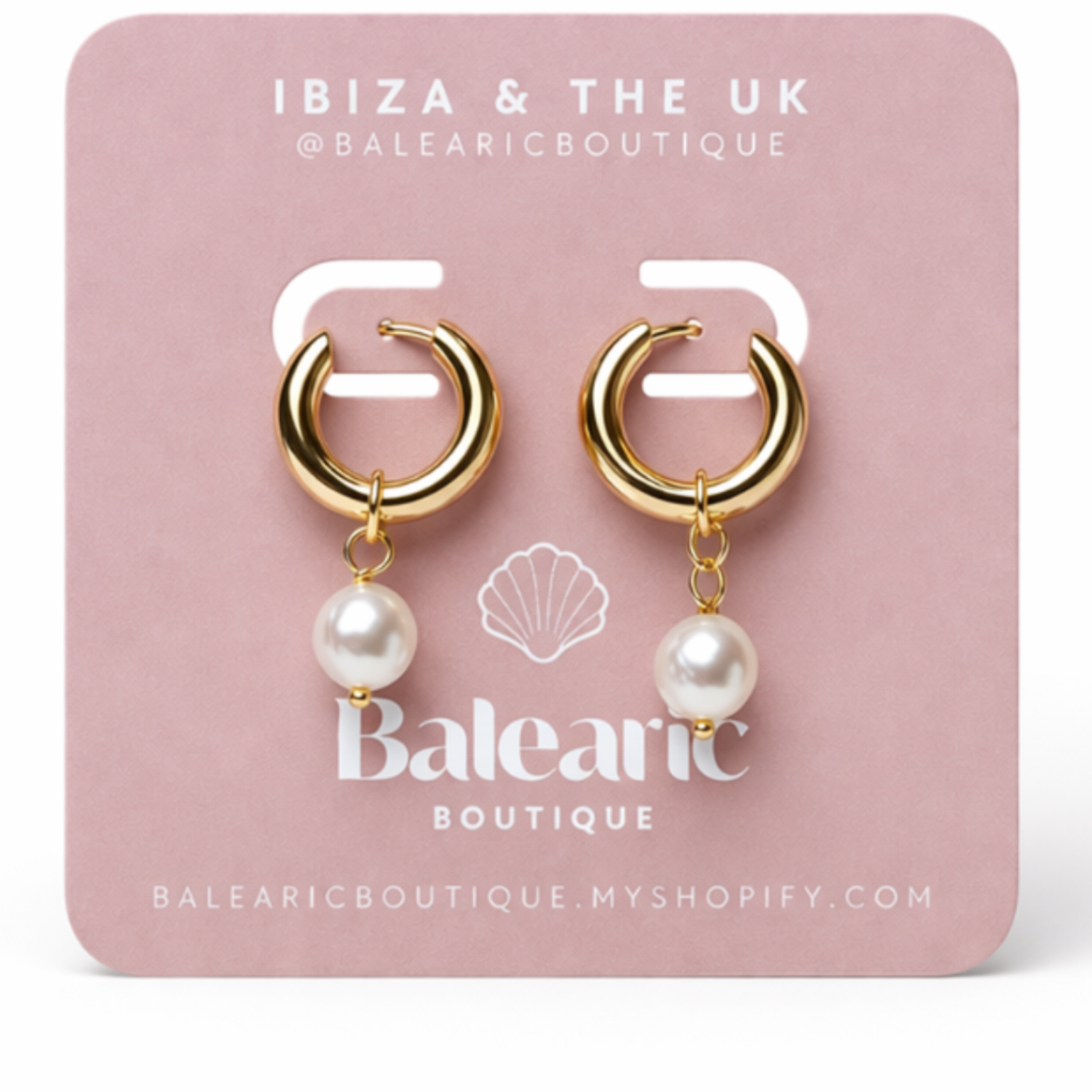 Gold hoop earrings with pearls on a pink card from Balnearic Boutique.