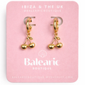 Gold cherry-shaped earrings on a pink card with 'Balearic Boutique' branding.