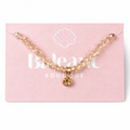 bracelet with a gold charm on a pink card with 'Belenic Boutique' branding.