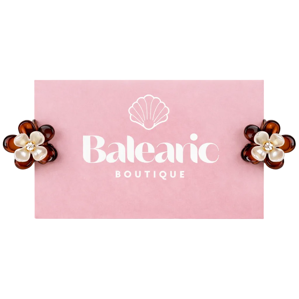 Pair of flower-shaped earrings with pearl centers on a pink card with 'Balearon Boutique' logo.