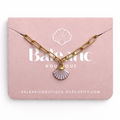 Gold chain bracelet with a shell pendant on a pink 'Balearic Boutique' card.