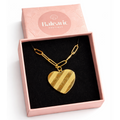 Gold heart-shaped necklace in a pink box with 'Balearic Boutique' branding.