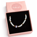 necklace with a blue evil eye bead in a pink 'Balearic Boutique' box on a white background