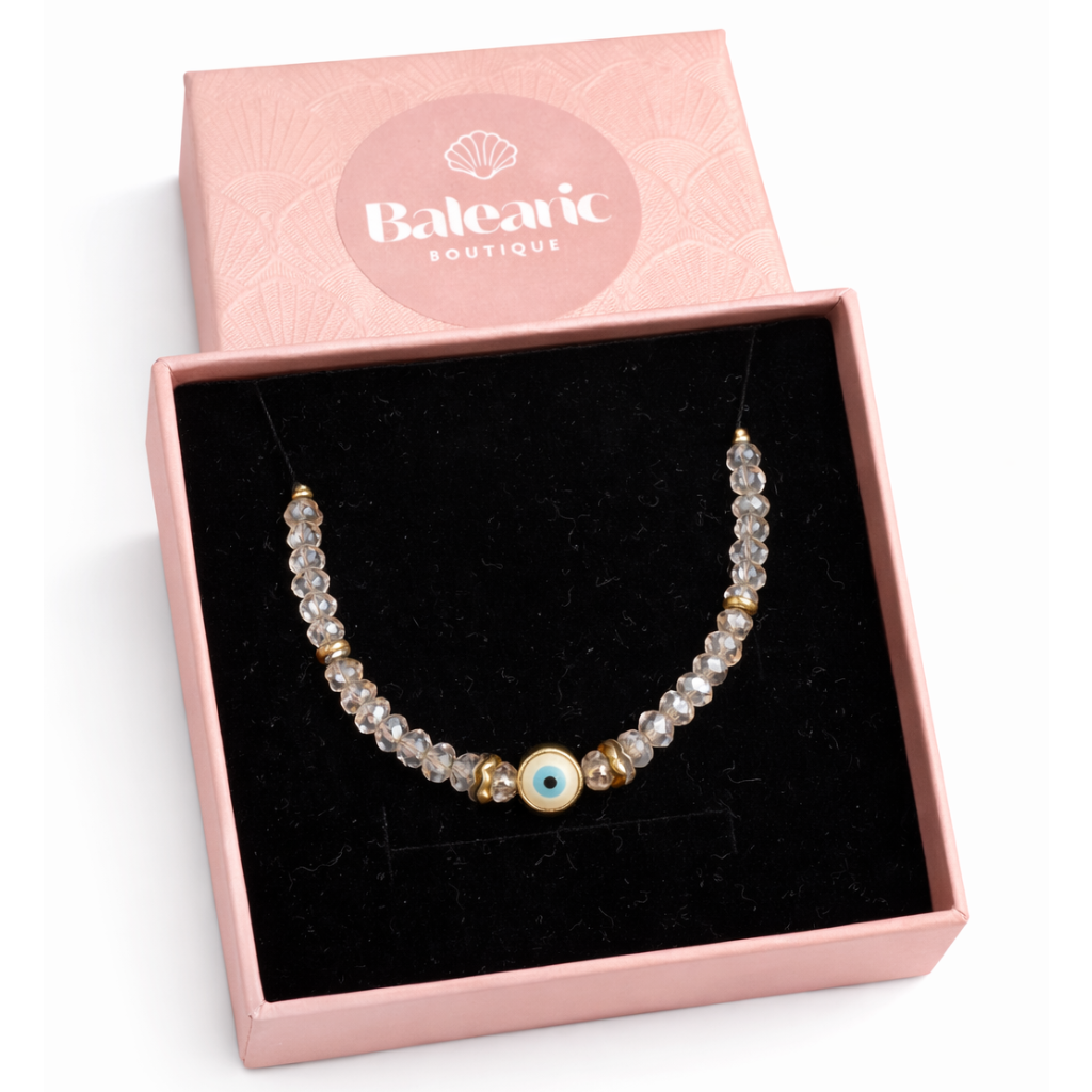 Pearl bracelet with gold and blue accents in a pink 'Balearic Boutique' box on a white background
