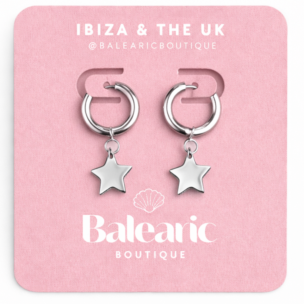 Pair of silver hoop earrings with star charms on a pink card from Balenarc Boutique.