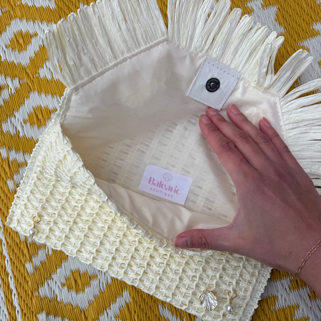 Cream-colored textured bag with a brand label on a yellow patterned surface