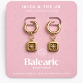 Gold earrings on a pink card with 'Balcaric' branding